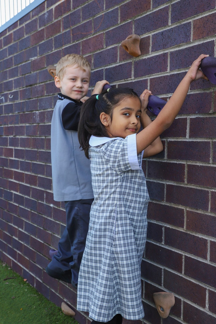Male and female student on climbing wall