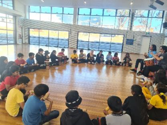Students sitting in circle in drumming group
