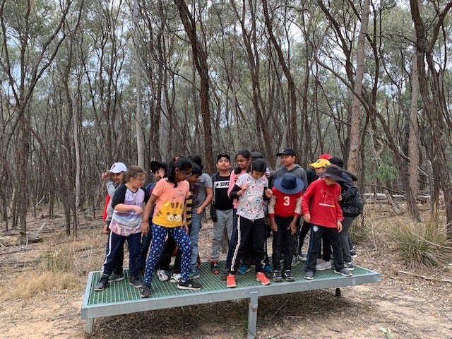 Group of students standing together on a platform outside