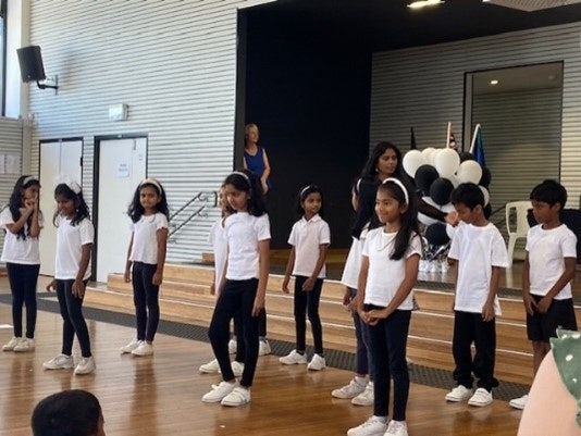 Group of students dressed in black and white performing a dance