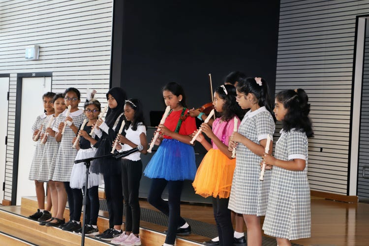 Students playing recorders for performance
