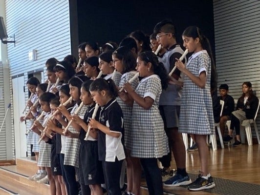 Group of students playing recorder on stage